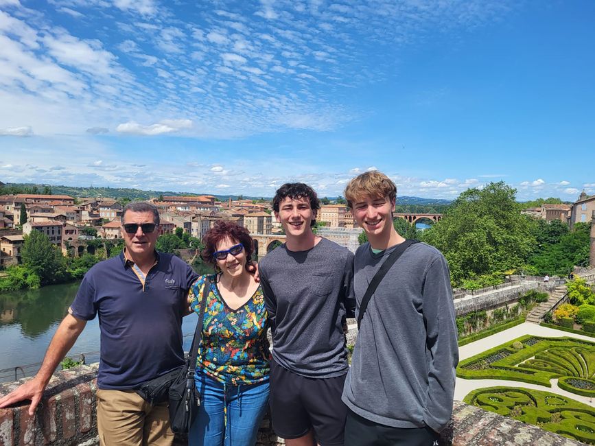 High school students with their host family touring gardens