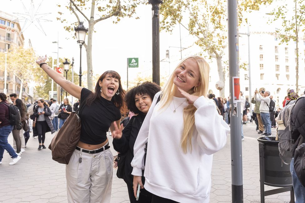 Three girls on study abroad program smiling by bus stop