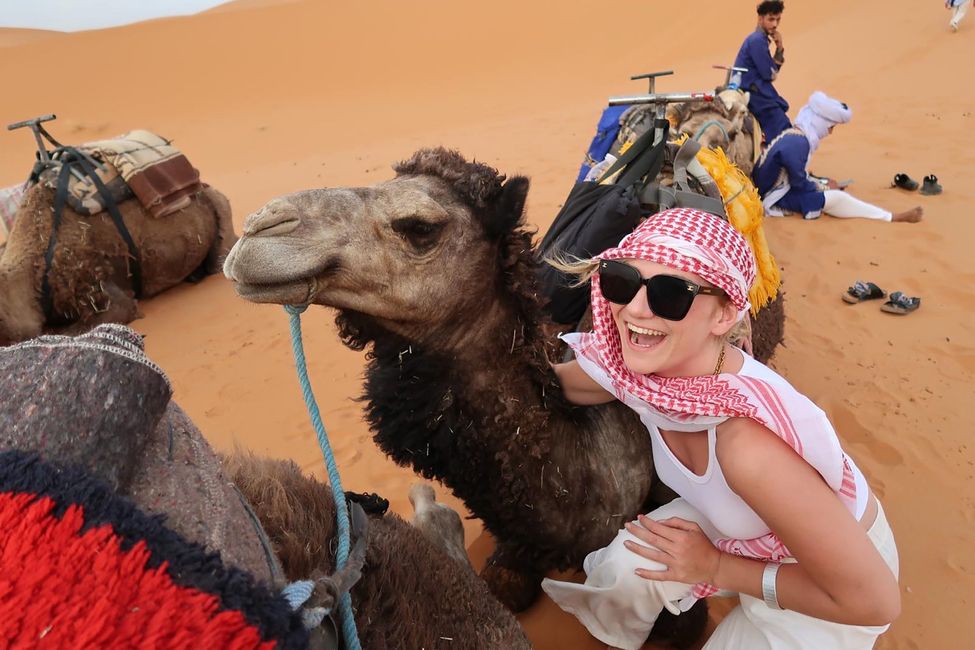 Student in the desert of Morocco posing with a camel