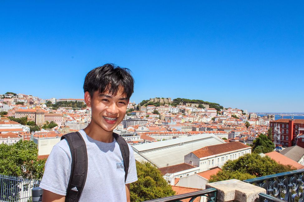 High school boy posing above city skyline while studying abroad