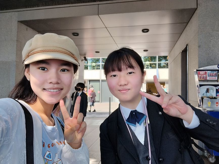 Two high school girls posing with peace signs in school hallway