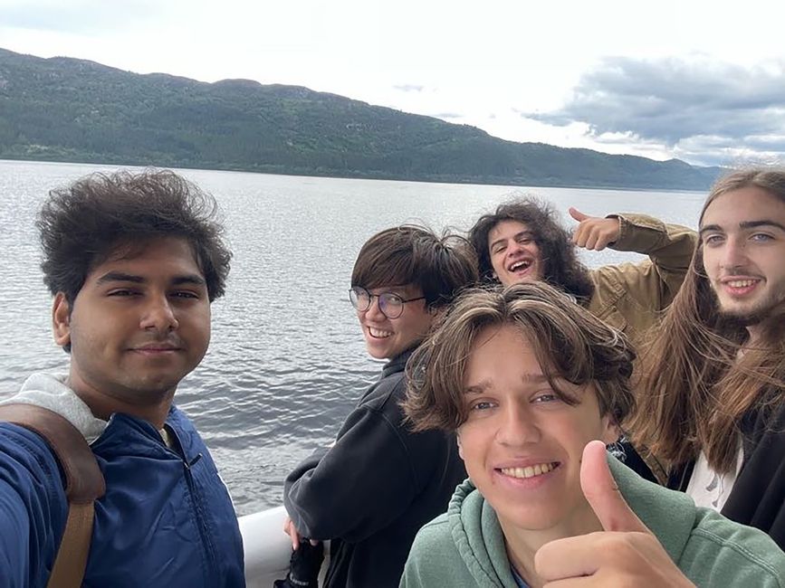 Participants smiling and thumbs upping on a boat