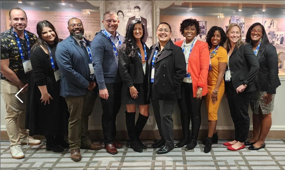 A row of adults standing together smiling