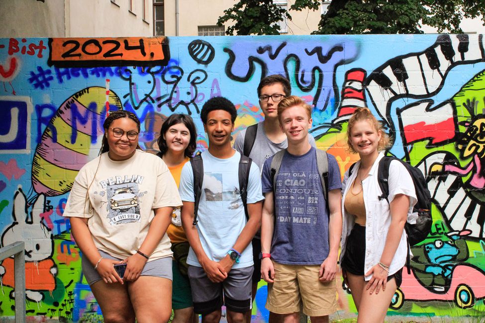 Teenagers posing in front of graffiti wall