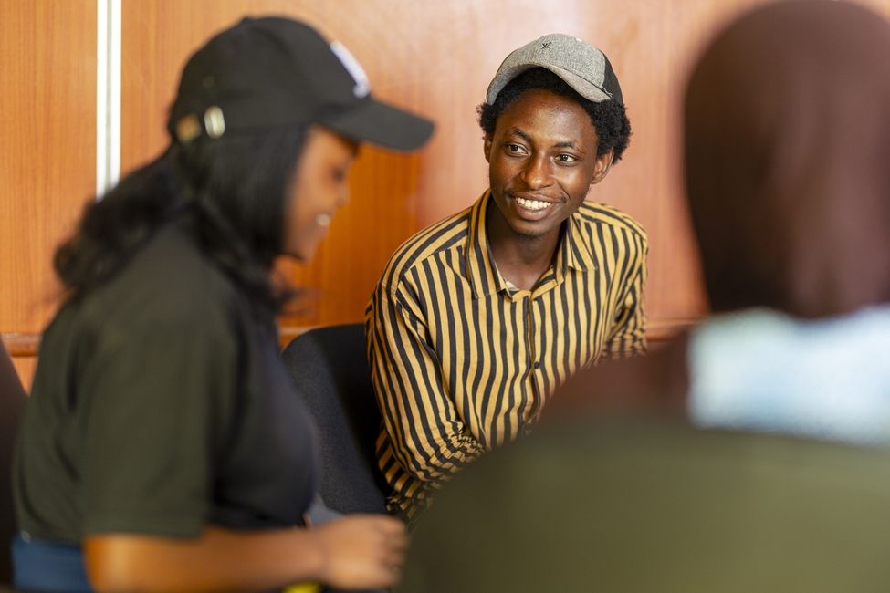 a student in a cap smiling at another student in a cap