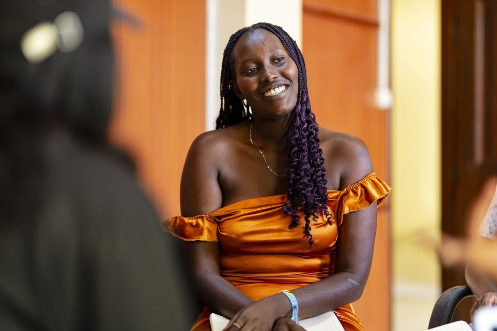 a female student smiling at looking at other students