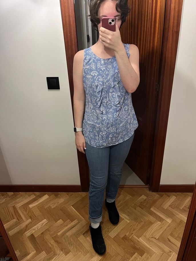A blue sleeveless blouse and jeans