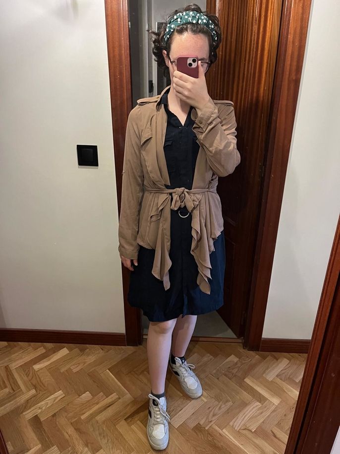The author wearing a dress, a jacket, and white shoes