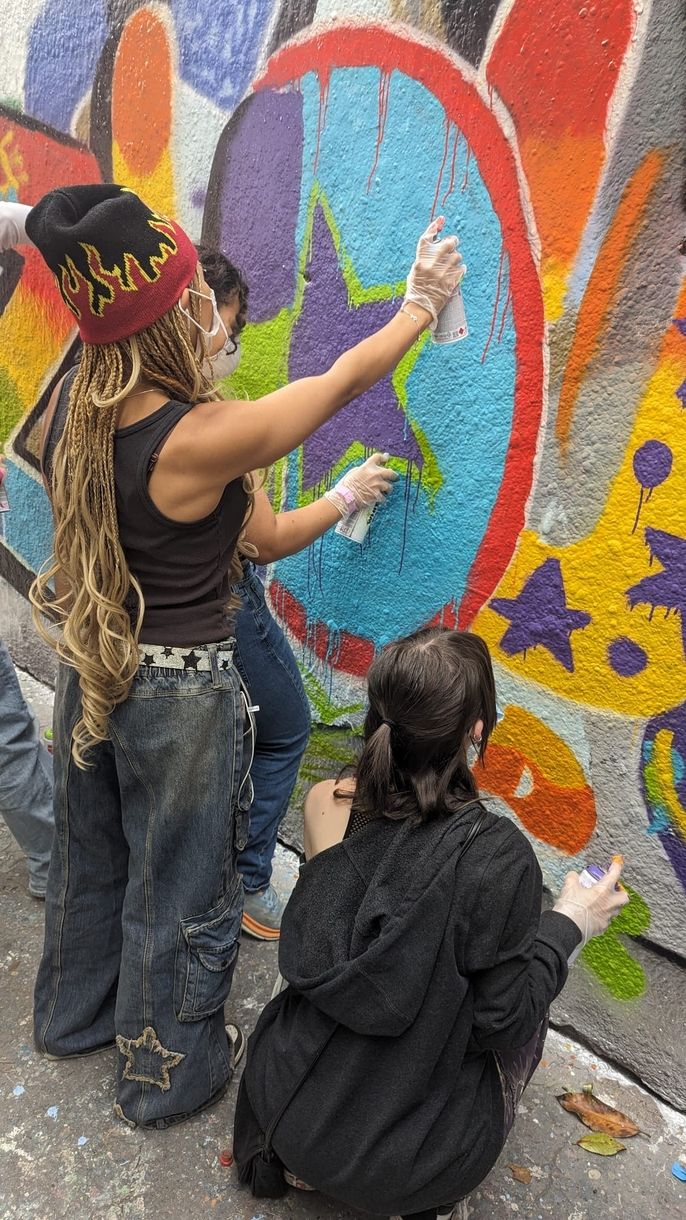 A group of three HSSA students work together on the letter O in their graffiti mural. 
