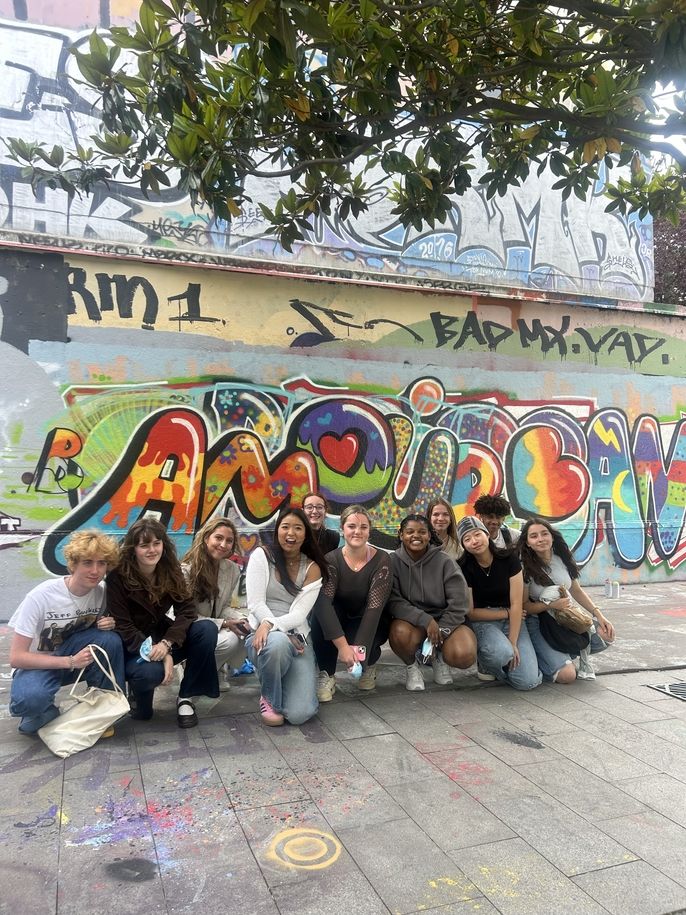 HSSA students pose in front of their finished mural. It smells out "Amour", which means love in French. 