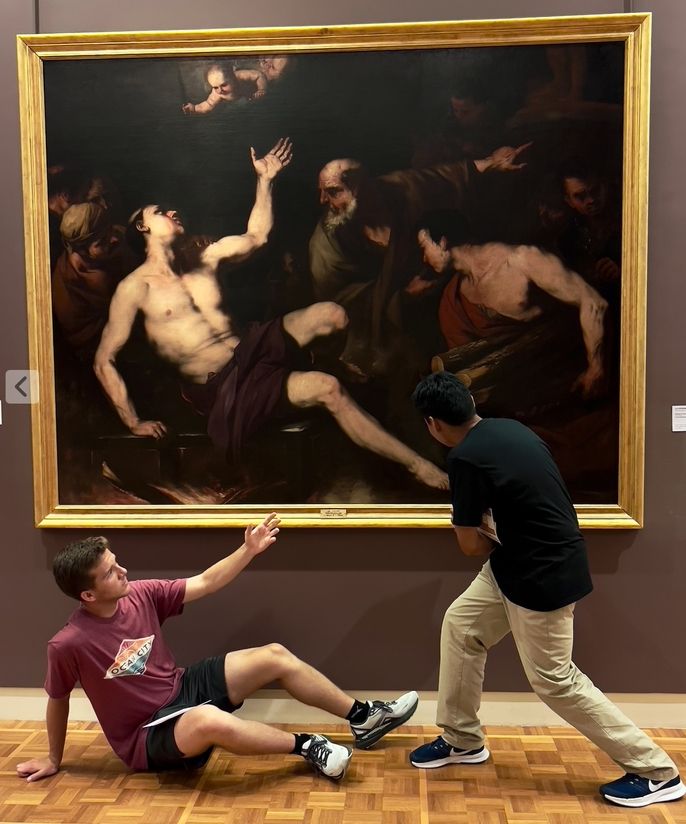 Two male students trying to imitate a work of art