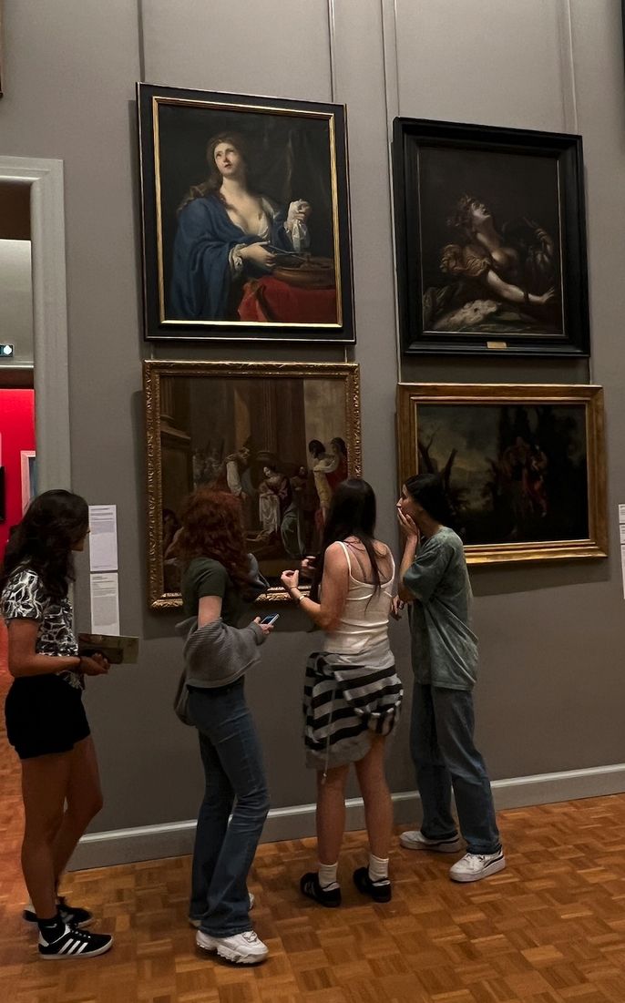 4 female students looking at a painting