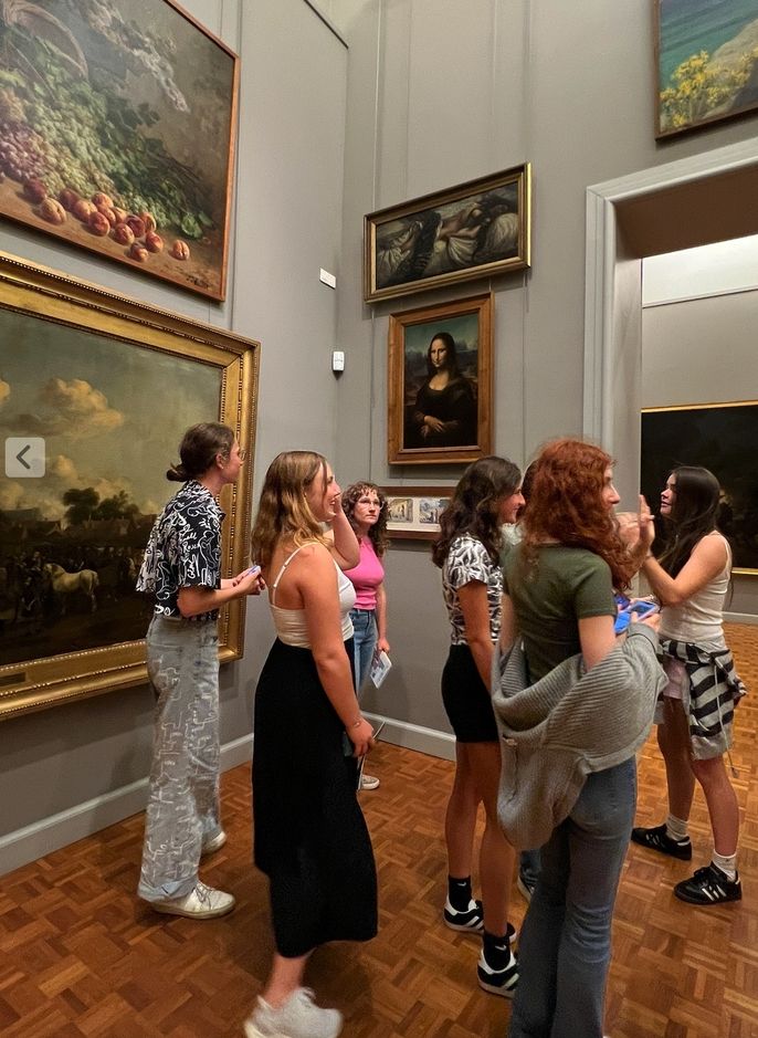 6 female students looking at art