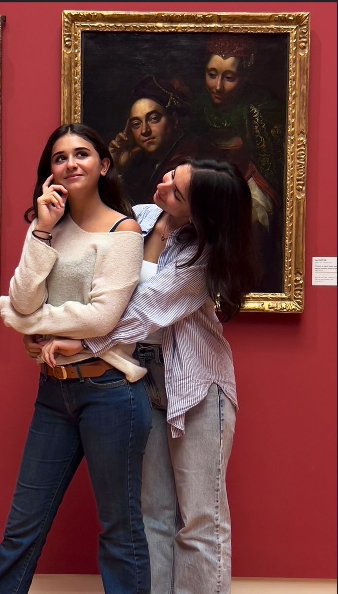 Two female students trying to imitate the scene of a painting
