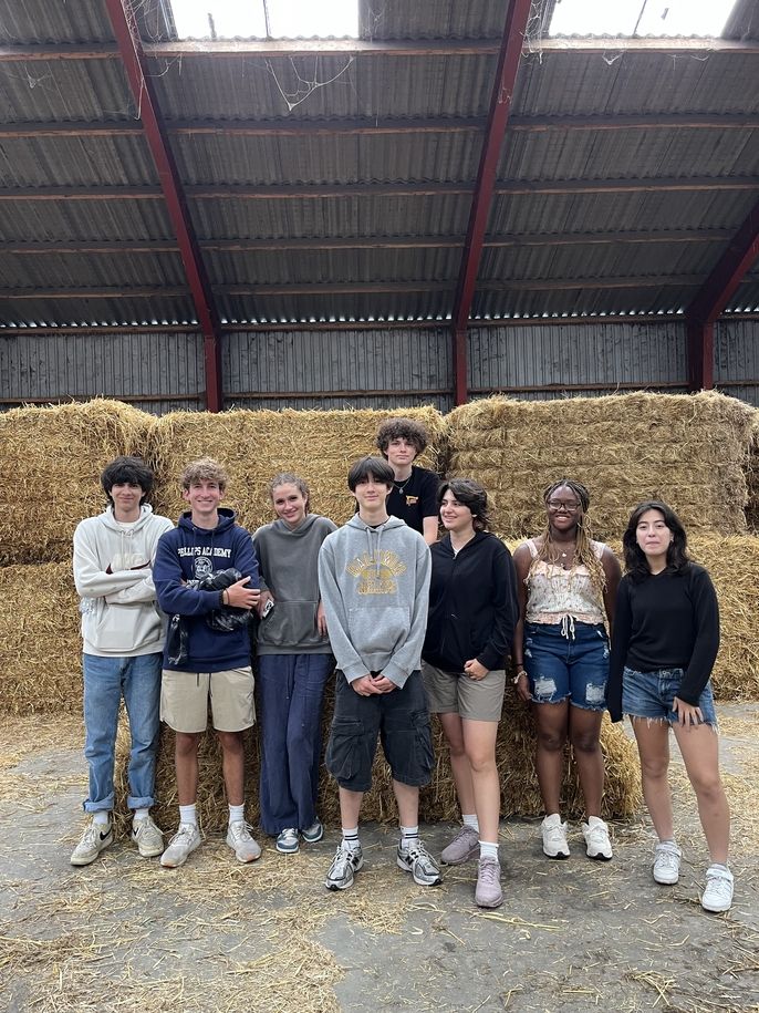 Group photo in front of hay bales at district heating plant.