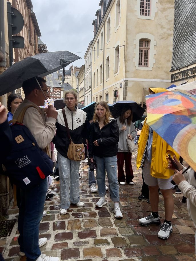 students listening to the program leader in the rain