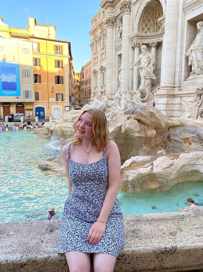 Global Navigator student sitting on Trevi Fountain smiling