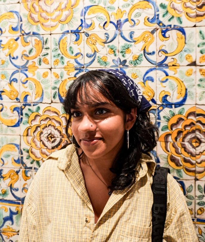 Student next to a tile mural