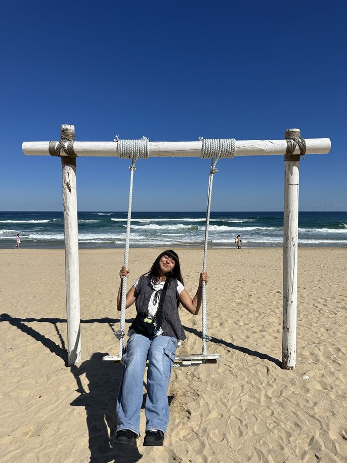 Author swining on swing on beach