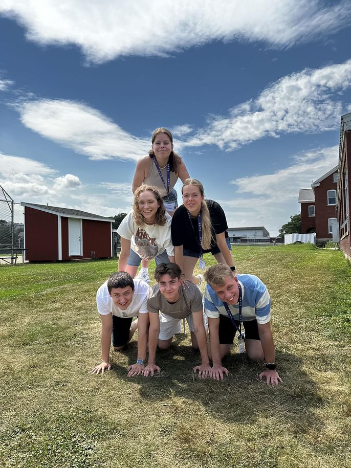 Pyramid of students posing in a field while studying abroad