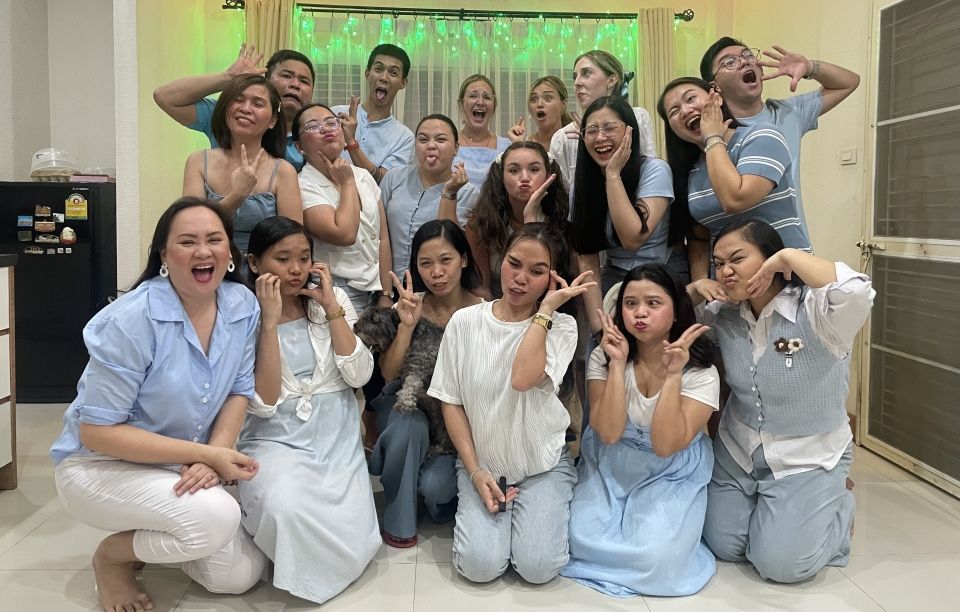 Large group of people dressed in blue and white strike a funny pose