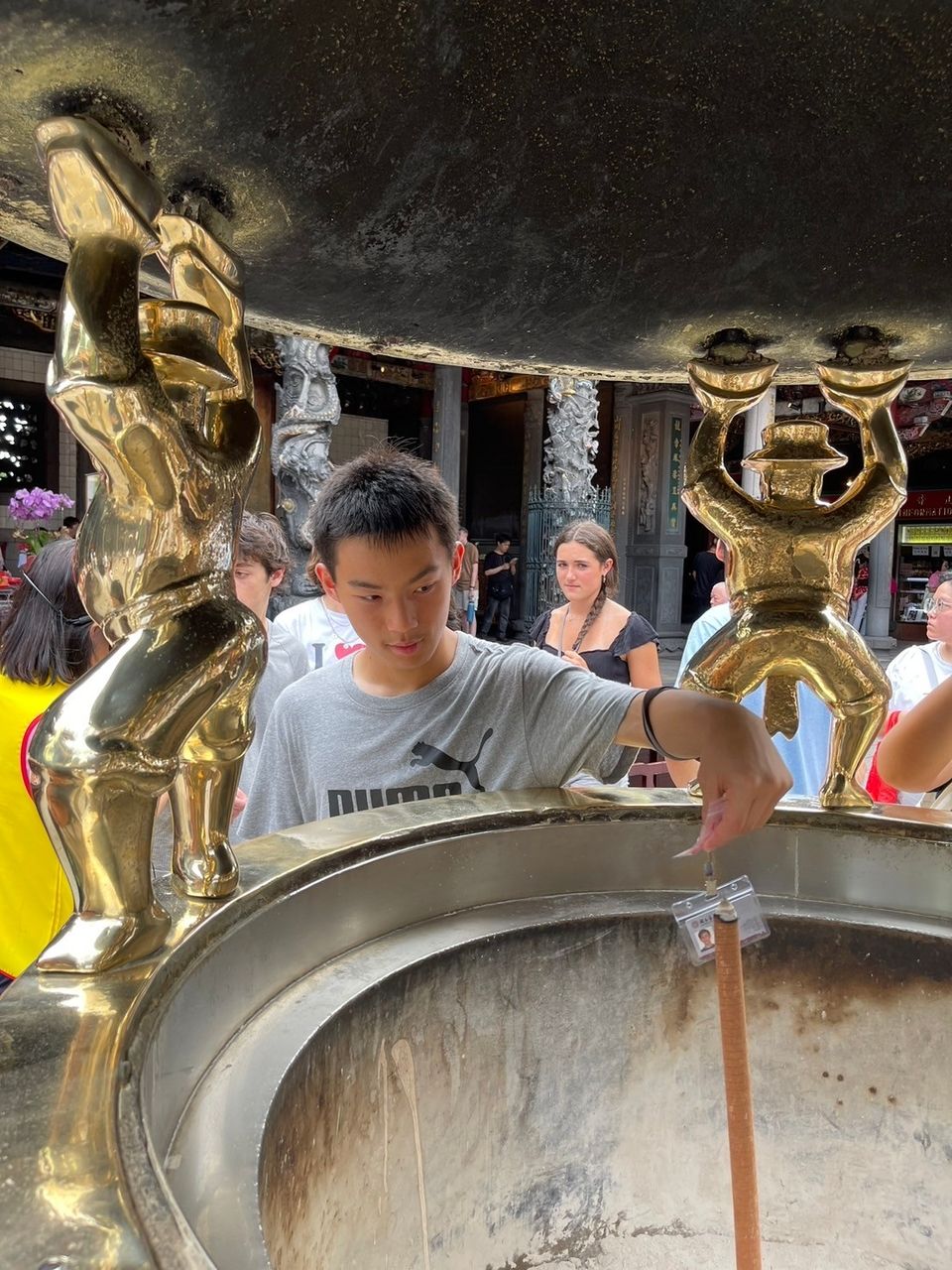 A student drops wishes into the incense burner.