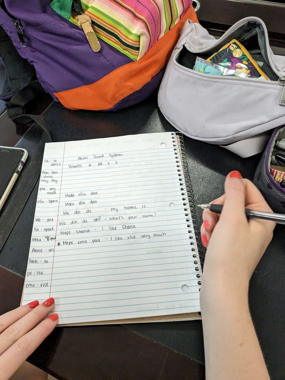 This is a photo of a page in a student's notebook. The page has some Twi words and phrases the student has put down from the first day of their Twi language lessons.