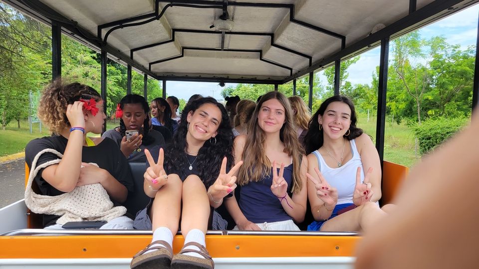 Group of friends embracing the tour train ride through the garden grounds.