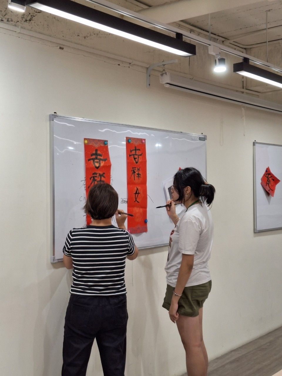 Teacher showing a student how to make spring couplets on a white board