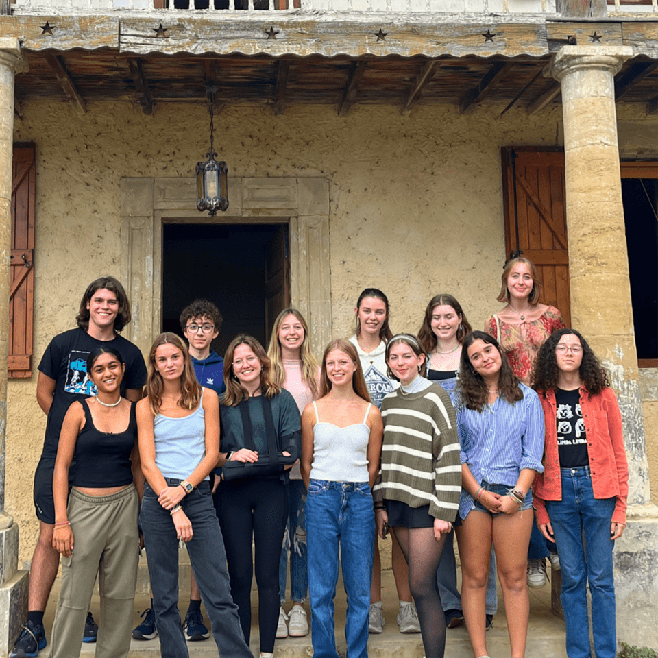 Students posing in front of a farm in France